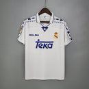 Camiseta oficial del Real Madrid primera equipación temporada 1996 1997 blanca retro para hombre de Tienda Hincha Futbolero, diseño legendario de Raúl y Roberto Carlos, Camiseta Real Madrid retro, Real Madrid 96/97, Ropa Real Madrid vintage, Comprar camiseta Real Madrid blanca, Raúl González Madrid, Roberto Carlos, Madridistas, Merengues, Camisetas fútbol retro, Retro Real Madrid 1997, Historia Real Madrid, Colección Madrid, Fútbol YEARS 90.