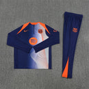 Chándal largo del FC Barcelona 2025 2026 conjunto pre-juego de sudadera y pantalón para hombre azul marino y naranja estilo Total 90 oficial Tienda Hincha Futbolero, Chándal Barcelona 2025, Conjunto largo FC Barcelona, Ropa de entrenamiento Barcelona 2026, Chándal oficial del Barça hombre, Comprar chándal Barcelona Total 90, Calidad premium Barcelona azul marino naranja, Sudadera Barcelona pre-juego, Ropa urbana blockecore, Chándal de colección culé.