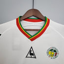 Camiseta hombre selección de Senegal mundial 2002 primera equipación blanca detalles verdes y amarillos retro calidad 1.1 premium Diouf Tienda Hincha Futbolero. Senegal 2002, Camiseta Senegal retro, Ropa Senegal fútbol, Camiseta Senegal 2002 blanca, Calidad 1.1 Senegal, Leones de Teranga Gear, Tienda Hincha Futbolero, Senegal Retro Jersey 2002.